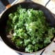 Kale is added to frying pan with chilli, garlic and onion
