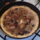 Egg starts to set around sausage and onion