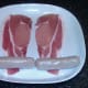 Preparing to roll chicken sausages in bacon