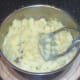 Potatoes are mashed with a hand-masher