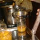 Peach preserves are ladled into preheated canning jars.