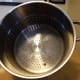 The top pan holds the fruit. As it steams, the juice drips down through the holes and collects in the middle pan.