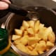 Once apples are peeled and chopped, put them in a pan. Pour lemon juice on top.