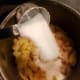 Add 1/4 cup of sugar. Stir. Then stir in additional 1/4 cup of sugar and allow apples to rest for two minutes.