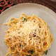 Serve the cooked pasta onto plates and top with some shredded Parmesan cheese.
