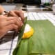Tightly roll the banana leaf from the bottom.