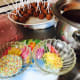 Multicolored sprinkles, cake pops, and melted dark chocolate couverture.