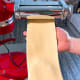 Without folding the dough, pass it through the next setting on the pasta machine. Keep reducing the space between the rollers after each pass.