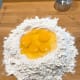 Form a well in the middle of the flour. Crack the eggs in the middle of the well.