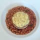 Pie with mash is plated on beans