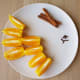 Add flavors: cut oranges, cinnamon, and cloves.