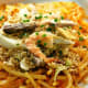 Pancit luglog: Thick rice noodles softened in hot water, stirred in a thickened shrimp sauce, and topped with steamed shrimp, hard-boiled egg, smoked fish, squid, and chopped pechay baguio.