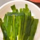 Use the pandan leaves to cover the bottom of the food steamer container. Lay them flat.