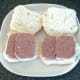 Slices of corned beef are laid on cut open bread rolls