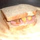 Top is placed on corned beef with spiced potatoes and onion sandwich