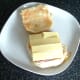Cheese slices are laid over corned beef, tomato and onion