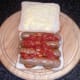 Tomato sauce is spooned on to sausages