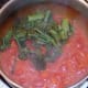 Chopped broccoli is added to spicy tomato sauce