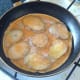 Beaten eggs are poured over fried potatoes