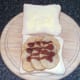 Brown sauce is drizzled over potatoes before sandwich is closed over with second slice of bread