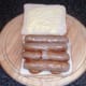 Halved sausages are laid on fried potatoes