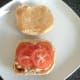 Tomato slices are laid on top the lettuce and onion combination