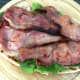Bacon rashers are arranged over chicken and curry sauce