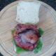 Bacon rashers are laid on lettuce and tomato