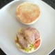 Sliced pork fillet and apple sauce are arranged on salad bed