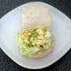 Mashed egg is spread out over lettuce bed
