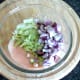 Shredded lettuce and diced red onion are added to chilli sauce