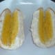 Rolls are cut and spread with mustard