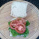 Lettuce and tomato are arranged on roll