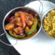 Potato and bell pepper rogan josh and turmeric and coriander rice are spooned in to serving dishes and sat on serving plate