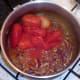 Tomatoes are added to onions and spices