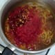 Tomatoes and dried chillies are added to spiced and softened onion