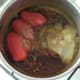 Tomatoes and apple sauce are added to spiced onions