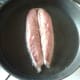 Mackerel fillet is laid in frying pan skin side down
