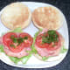 Tomato slices are laid on bacon