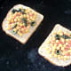 Sandwich filling is spread on bread on grill pan