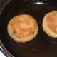 Potato cakes are turned to fry on second side