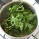 Spinach leaves are added to cooked lamb