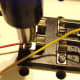 Unscrew one of the screws of the knife switch and wrap loop around neck of screw. Tighten the screw gently again using the screw driver.