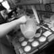Pouring cupcake batter in pans.