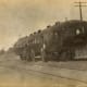 Railroad men in their uniform standing by an unusual passenger railroad car, Heavener