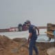 Volunteers helping pour in sand for the brick base.
