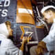 Wally Schirra observes as Cece Bibby paints the Sigma 7 logo. Photo courtesy of NASA.