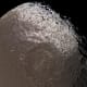 Saturn's moon Iapetus is a puzzle: its backside is light-colored, and its leading hemisphere is mostly coated with a muddy brown...something...that appears to have splattered it from another moon, the rings, or an unknown source.