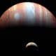 Jupiter and Io photographed by the New Horizons space probe to Pluto, passing by in 2007. (Jupiter is captured in infrared, which maps heat, so the Great Red Spot looks white). Note eruption plume on Io's pole (right).