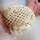Press your hands against the pie plate to cut the excess strips of dough, working your way around the outside, turning the pie as you go.